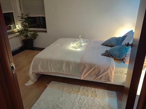 a white bed with blue pillows in a room at Apartman K2 in Žarkovo