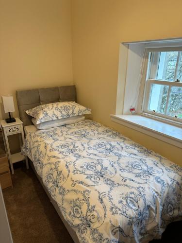 a bedroom with a bed with a blue and white comforter at Kilmory in Arisaig