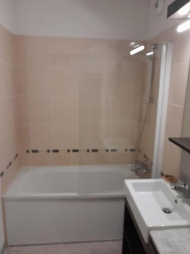 une salle de bain avec une baignoire blanche et un lavabo dans l'établissement Val d'Azur Plein sud Face aux Pistes, à Valberg