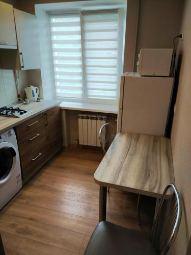 a kitchen with a refrigerator and a table and a microwave at Lux Apartment Вокзал. Надежды Алексеенко 30 in Dnipro