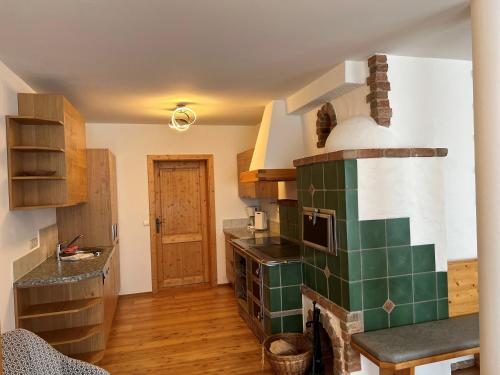 a kitchen with a green and white tile fireplace at Mei Zeit Hüttendorf in Turracher Hohe