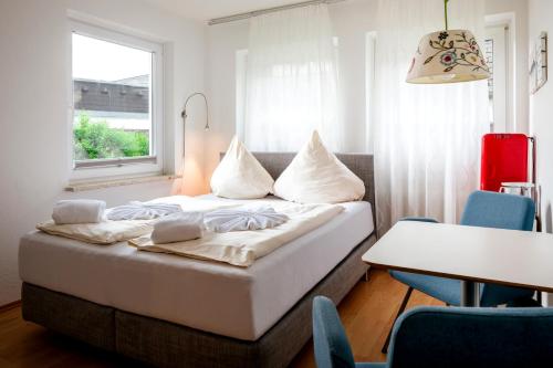 a bedroom with a bed and a table and a window at Greenhouse Apartments in Helgoland
