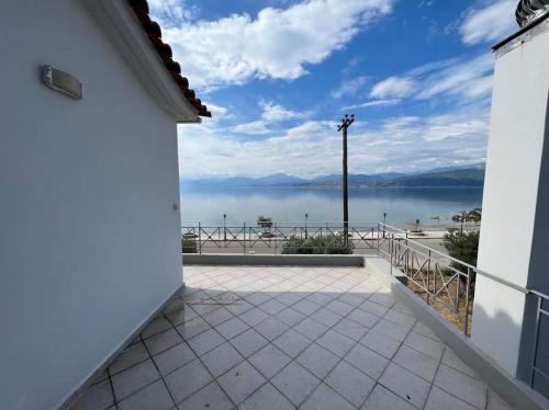 a balcony with a view of the water at Nafpaktos Shingle Villa in Nafpaktos