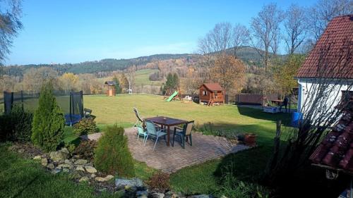 a patio with a table and chairs in a yard at Chalupa u Pilných in Kaplice