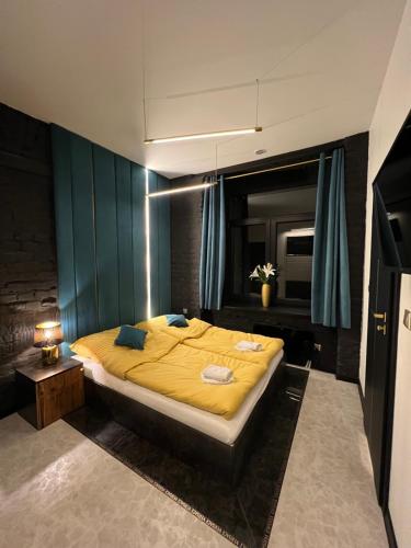 a bedroom with a large bed with yellow sheets at DarkHouse Versace Blue in Łódź