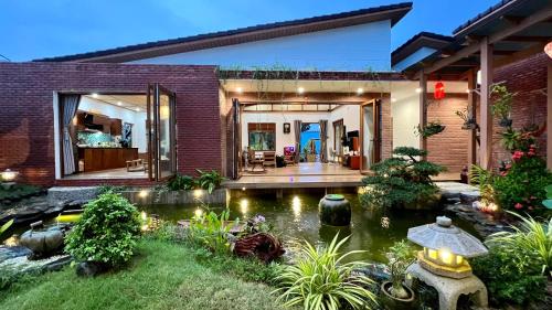 a house with a koi pond in the yard at Sakura Mura Homestay Phú Quốc in Phu Quoc