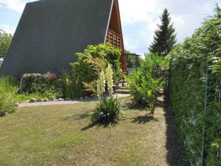 a garden in front of a church with a building at Ferienhaus _Achterblick_ Gerlinde in Ueckeritz