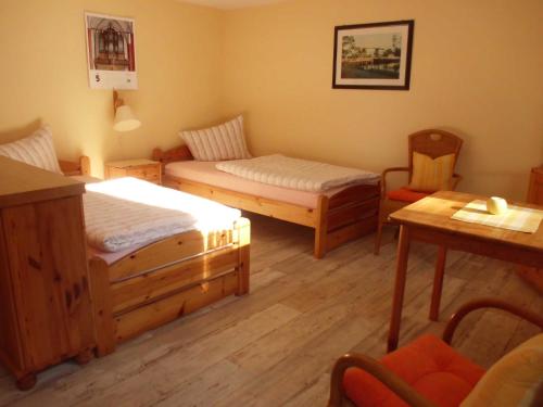 a room with two beds and a table and chairs at Ferienwohnung Familie Maas in Neuenkirchen