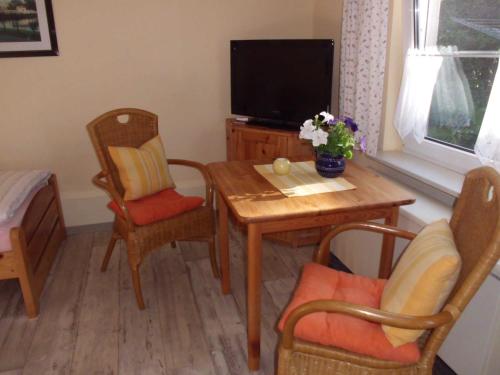 a living room with a table and chairs and a television at Ferienwohnung Familie Maas in Neuenkirchen