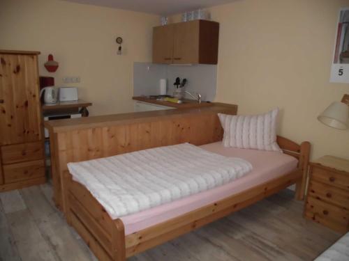 a bedroom with a wooden bed in a room at Ferienwohnung Familie Maas in Neuenkirchen