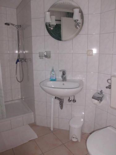 a bathroom with a sink and a shower and a toilet at Ferienwohnung Familie Maas in Neuenkirchen