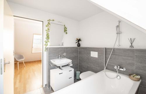 a bathroom with a sink and a bath tub at Modern 3BDR Duplex with Skyroof in Trendy Zurich West in Zurich