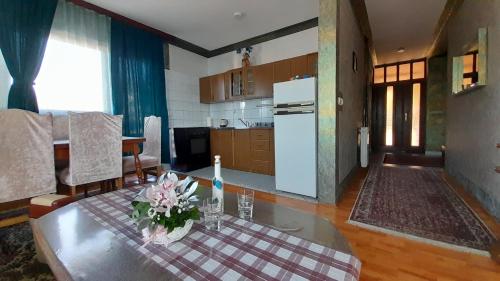 eine Küche und ein Wohnzimmer mit einem Tisch mit Blumen darauf in der Unterkunft Romansa in Pale