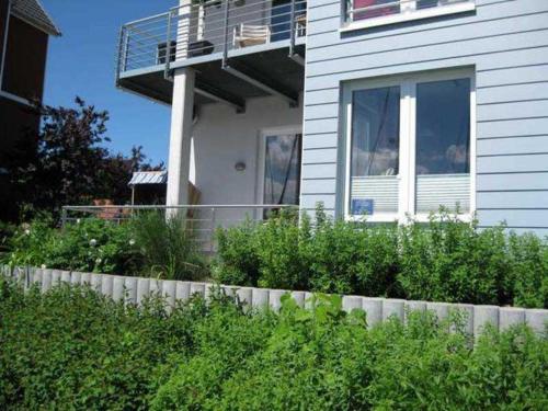 Casa blanca con balcón y valla en Ferienwohnungen Am Yachthafen, en Greifswald