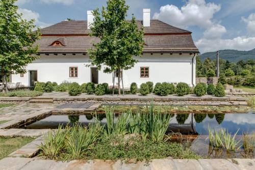 a house with a pond in front of it at Boutique hotel Mezi plutky in Čeladná
