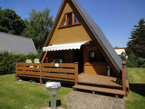 a home with a wooden deck with a roof at Finnhuette Cathleen Schulz in Eldena