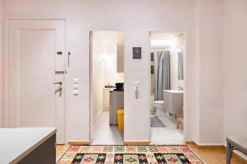 a white room with a bathroom with a sink and a toilet at Bang in Kolonaki by Athenian Homes in Athens