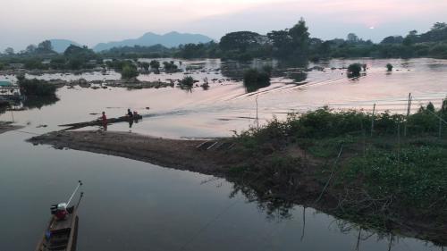 a river with people standing in the water at Kulap Kao Bungalow in Ban Donsôm Tai