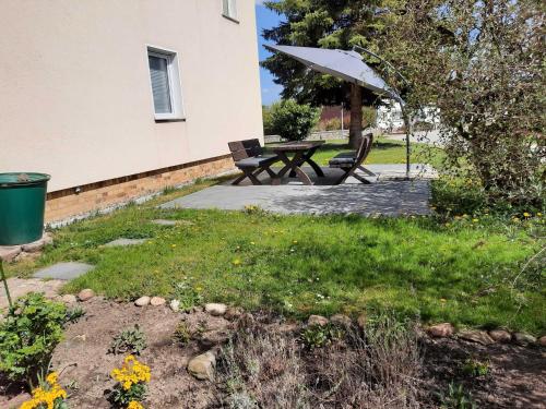 einen Picknicktisch und einen Regenschirm im Hof in der Unterkunft Peene Alte Schule Völschow Dornberger 