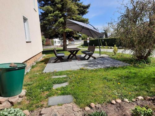 eine Terrasse mit einem Tisch, Stühlen und einem Sonnenschirm in der Unterkunft Peene Alte Schule Völschow Dornberger 