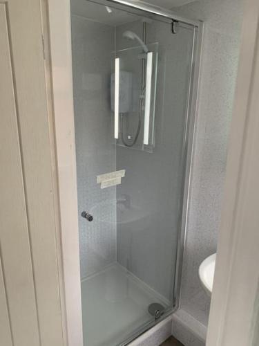 a glass shower in a bathroom with a sink at Town Centre Getaway in Southport