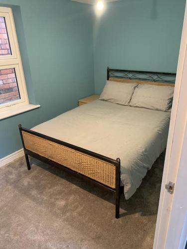 a bed in a bedroom with a blue wall at Town Centre Getaway in Southport
