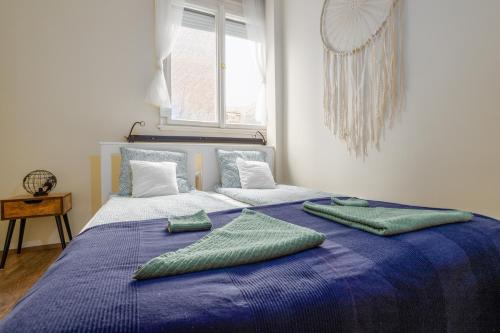 un letto blu con due cuscini verdi sopra di Golden Hour Apartment a Budapest