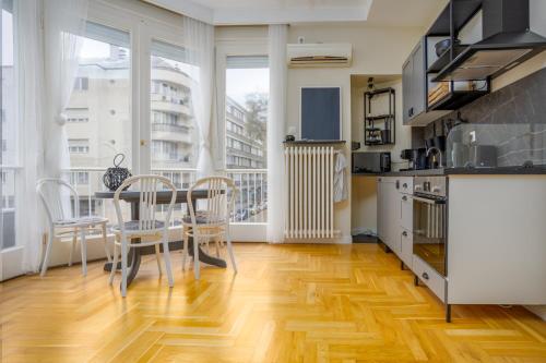 una cucina e una sala da pranzo con tavolo e sedie di Golden Hour Apartment a Budapest