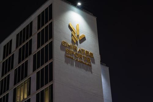a building with a sign on the side of it at Emirates Sports Hotel, Dubai Sports City in Dubai