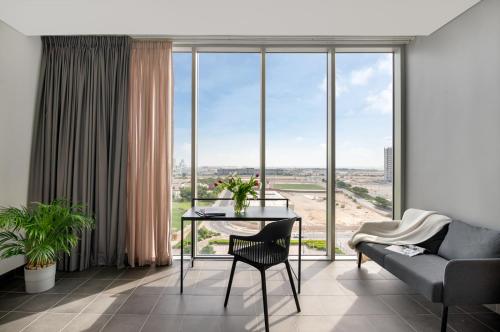 a living room with a table and a couch at Emirates Sports Hotel, Dubai Sports City in Dubai