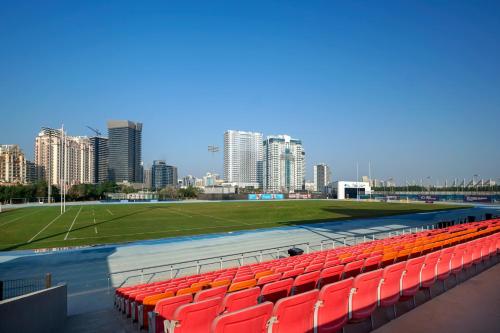 a stadium with red seats and a soccer field at Emirates Sports Hotel, Dubai Sports City in Dubai
