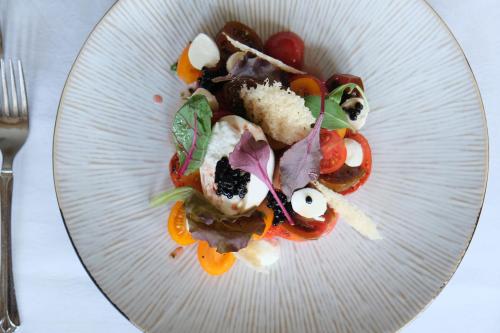 a white plate of food on a table at Haller's Geniesserhotel in Mittelberg