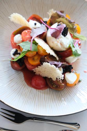 a plate of food with tomatoes and other vegetables at Haller's Geniesserhotel in Mittelberg