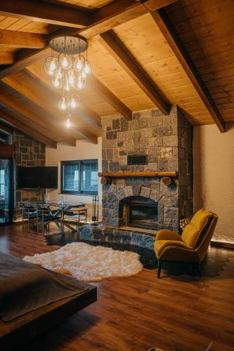 a living room with a stone fireplace and a couch at Çathan Art Hotel in Ayder Yaylasi