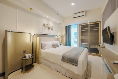 Habitación de hotel con cama y TV en Yoonah at Benson Pakuwon Mall en Lontar