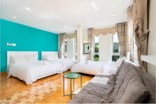 頭頓的住宿－Sunset Bãi Dâu Boutique Hotel Vũng Tàu，一间带两张床和一张沙发的客厅