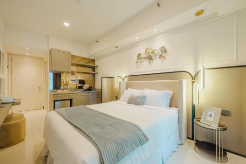 a bedroom with a large bed and a kitchen at Yoonah at Benson Pakuwon Mall in Lontar