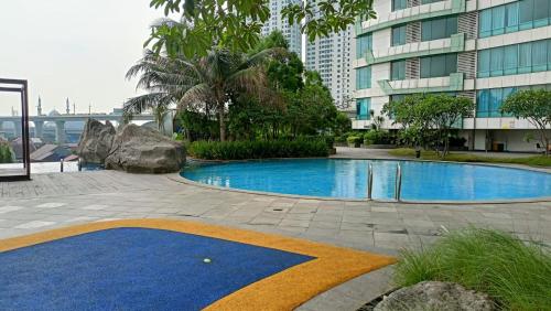 una piscina al centro di un edificio di Mushroom Apartment Grand Kamala Lagoon by Mrs Sewa a Pekayon Satu