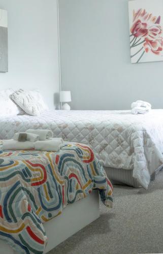 a bedroom with a white bed with a colorful comforter at Sylvan Beach Resort in Bellara