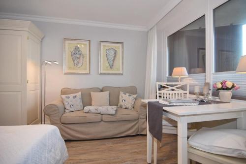 a living room with a couch and a table at Appartement Nordmuschel in Westerland in Westerland (Sylt)