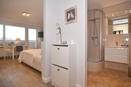 een slaapkamer met een bed en een badkamer met een douche bij Appartement Nordmuschel in Westerland in Westerland
