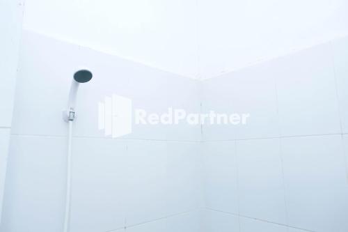 a bathroom with a red partner sign on the wall at Fortuner Homestay Syariah Makassar Mitra RedDoorz in Pampang