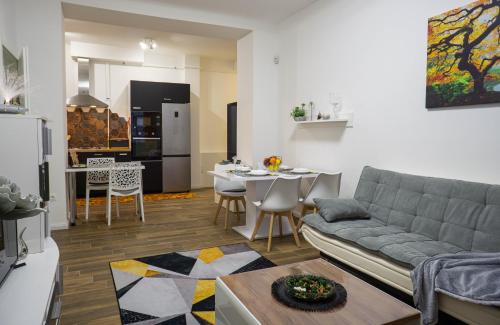 sala de estar con sofá y cocina con mesa en Cosy Casa en Budapest