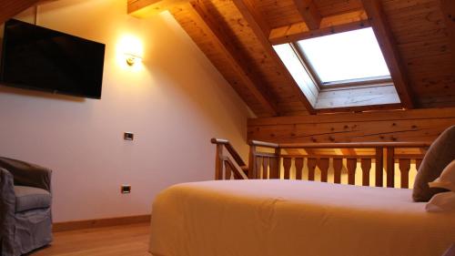 a bedroom with a bed and a flat screen tv at Villa Bonomo Charme Hotel in Asiago