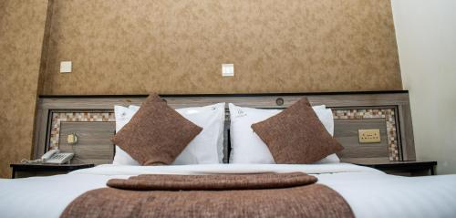 a bedroom with a large bed with white sheets and pillows at Astorian Grand Hotel Naivasha in Naivasha