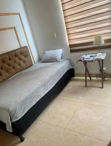 - un petit lit dans une chambre avec une table de chevet dans l'établissement Casa a 650 metros Estación metro la Floresta., à Medellín