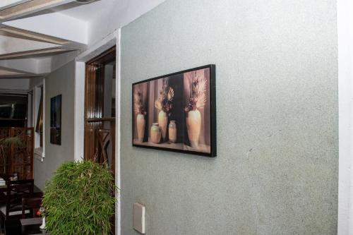 a picture on a wall with a picture of vases at Astorian Grand Hotel Naivasha in Naivasha