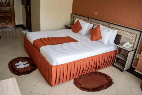 a large bed in a room with rugs on the floor at Astorian Grand Hotel Naivasha in Naivasha