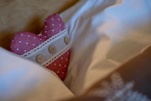 a pink and white bow tie sitting on a bed at Starkenfeldhütte in Rodengo