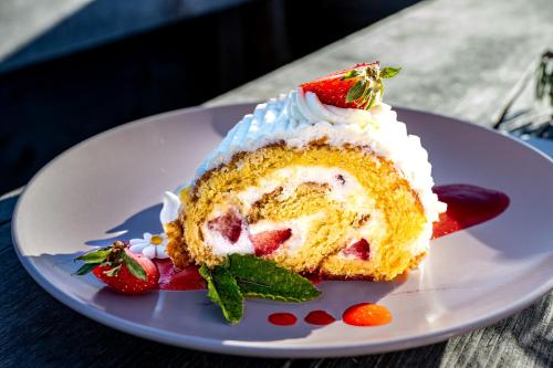 a piece of cake with strawberries on a white plate at Starkenfeldhütte in Rodengo